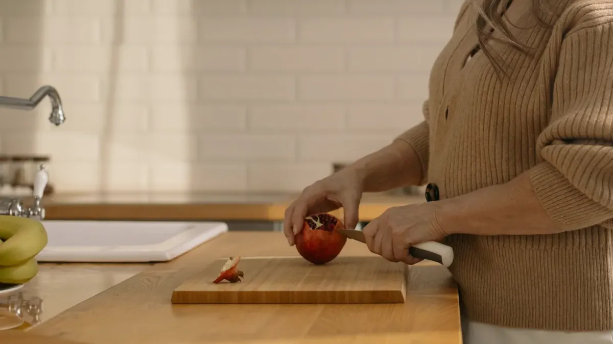 Sliced banana on a wooden cutting board with a dog watching nearby